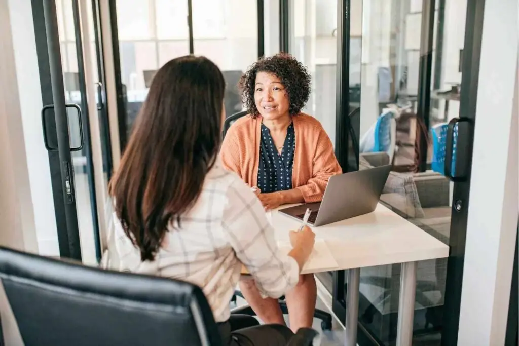 Small business owner interviewing a candidate when preparing to hire a first employee in Australia.